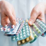 Hand of doctors holding many different pills